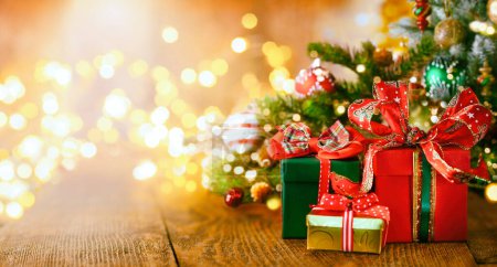 Téléchargez les photos : Noël ou Nouvel An nature morte avec des boîtes-cadeaux et des boules sous l'arbre de Noël sur une table en bois. Concept festif. - en image libre de droit