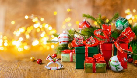 Téléchargez les photos : Noël ou Nouvel An nature morte avec des boîtes-cadeaux, branches de sapin et boules de Noël sur une table en bois. Concept festif. - en image libre de droit