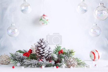 Téléchargez les photos : Noël nature morte avec des cônes de pin neigeux, des boules et des branches de sapin sur fond clair. Concept de fête d'hiver ou de Noël. - en image libre de droit