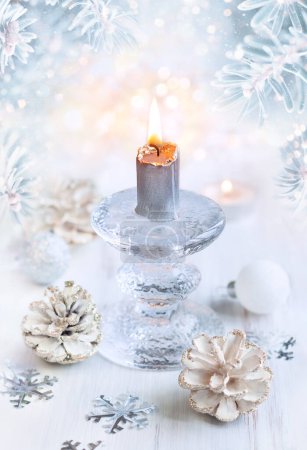 Photo for Christmas winter still life with burning candle, pine cones and snowflakes on light background. - Royalty Free Image