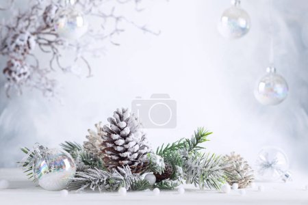 Téléchargez les photos : Noël nature morte avec des cônes de pin neigeux, des boules et des branches de sapin sur fond clair. Concept de fête d'hiver ou de Noël. - en image libre de droit