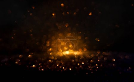 Téléchargez les photos : Des lumières bokeh dorées chaudes illuminent une toile de fond sombre, créant un motif abstrait d'orbes brillantes douces idéales pour les arrière-plans. Bokeh de brillance floue pour effet de superposition. - en image libre de droit