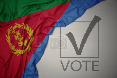 Foto de Ondeando colorida bandera nacional de eritrea sobre un fondo gris con voto de texto. concepto de elección. Ilustración 3D - Imagen libre de derechos