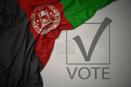 Foto de Ondeando colorida bandera nacional de Afganistán sobre un fondo gris con voto de texto. concepto de elección. Ilustración 3D - Imagen libre de derechos