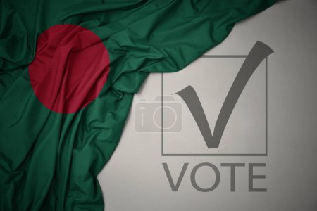 Foto de Ondeando colorida bandera nacional de bangladesh sobre un fondo gris con voto de texto. concepto de elección. Ilustración 3D - Imagen libre de derechos