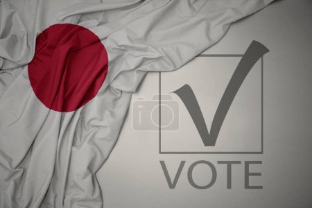 Foto de Ondeando colorida bandera nacional de Japón sobre un fondo gris con voto de texto. concepto de elección. Ilustración 3D - Imagen libre de derechos