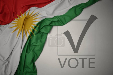 Foto de Ondeando colorida bandera nacional de Kurdistán sobre un fondo gris con voto de texto. concepto de elección. Ilustración 3D - Imagen libre de derechos