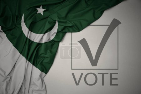Foto de Ondeando colorida bandera nacional de Pakistán sobre un fondo gris con voto de texto. concepto de elección. Ilustración 3D - Imagen libre de derechos