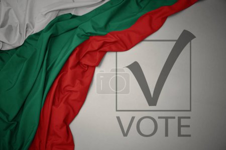 Foto de Ondeando colorida bandera nacional de bulgaria sobre un fondo gris con voto de texto. concepto de elección. Ilustración 3D - Imagen libre de derechos