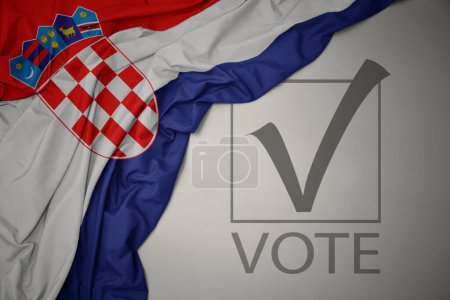Foto de Ondeando colorida bandera nacional de croacia sobre un fondo gris con voto de texto. concepto de elección. Ilustración 3D - Imagen libre de derechos