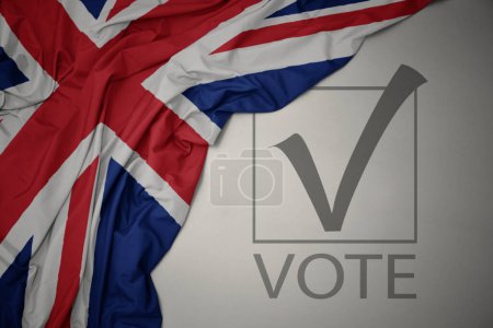Foto de Ondeando colorida bandera nacional de Gran Bretaña sobre un fondo gris con voto de texto. concepto de elección. Ilustración 3D - Imagen libre de derechos