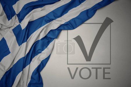 Foto de Ondeando colorida bandera nacional de Grecia sobre un fondo gris con voto de texto. concepto de elección. Ilustración 3D - Imagen libre de derechos