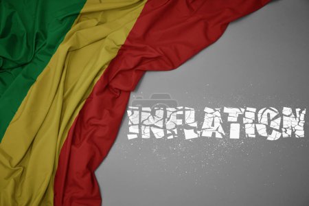 Foto de Ondeando colorida bandera nacional de la república del congo sobre un fondo gris con la inflación de texto roto. concepto. ilustración 3d - Imagen libre de derechos