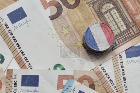 Foto de Moneda en euros con bandera nacional de Francia sobre el fondo de los billetes en euros - Imagen libre de derechos
