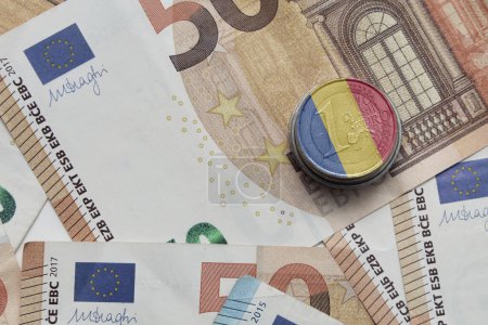 pièce en euros avec drapeau national coloré de la Roumanie sur le fond des billets en euros