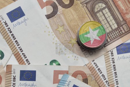 Foto de Moneda en euros con bandera nacional colorida de myanmar en el fondo de los billetes en euros - Imagen libre de derechos