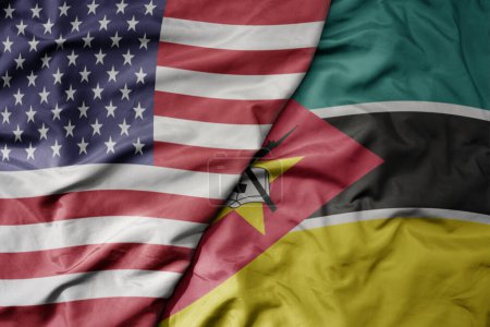 Foto de Gran ondeando colorida bandera de Estados Unidos de América y bandera nacional de Mozambique. macro - Imagen libre de derechos