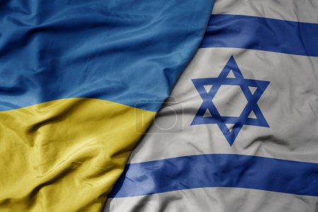 big waving national colorful flag of ukraine and national flag of israel . macro