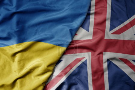 big waving national colorful flag of ukraine and national flag of great britain . macro