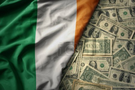 Téléchargez les photos : Grand drapeau national coloré agitant d'ireland sur un fond d'argent dollar américain. concept de financement - en image libre de droit
