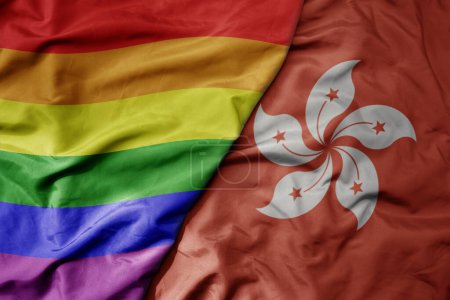 Foto de Gran ondeando bandera colorida nacional realista de Hong Kong y arco iris bandera orgullo gay. macro - Imagen libre de derechos