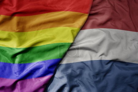 Foto de Gran ondeando bandera colorida nacional realista de los Países Bajos y arco iris bandera orgullo gay. macro - Imagen libre de derechos