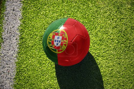 Téléchargez les photos : Ballon de football avec le drapeau national du Portugal sur le terrain vert près de la ligne blanche - en image libre de droit