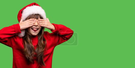 Photo for Happy xmas and New Year. Portrait of child funny girl in Santa red hat waiting for Christmas gifts. Smiling funny kid with closed eyes with hands in anticipation of miracle. High quality photo - Royalty Free Image