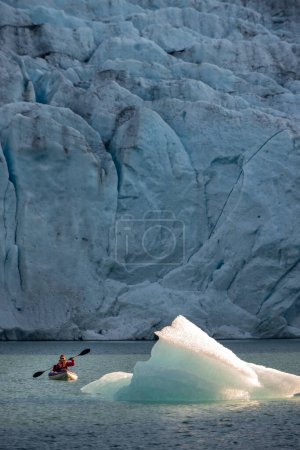Photo for Young Woman Kayaking Mosevatnet Lake with Folgefonna Glacier in the background, Visiting Norway - Royalty Free Image