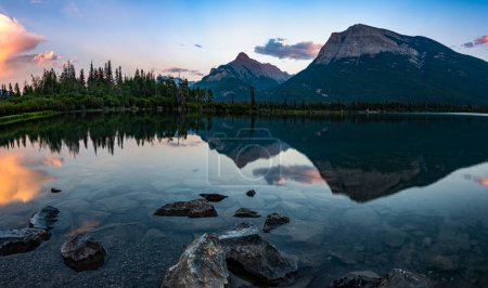 Téléchargez les photos : Lac Gap en Alberta, Canada, Après le coucher du soleil, reflet étonnant dans les eaux calmes reflètent les montagnes et le ciel coloré - en image libre de droit