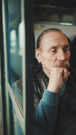 Primer plano retrato de anciano pensativo mientras viaja en tren coupé