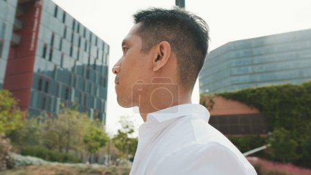 Photo for Close-up of young businessman walking down the street on modern buildings background - Royalty Free Image