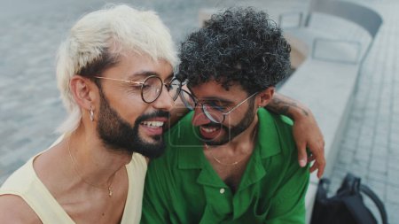 De cerca, homosexual amante pareja abrazando charlando animadamente en la calle