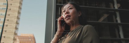 Photo for Young businesswoman talking on smartphone on business center background, Panorama - Royalty Free Image