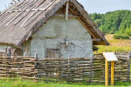 Foto de Una antigua casa de pueblo con un cráneo de animal encima de la puerta hecha de piedra y arcilla con un techo de vigas de madera seca - Imagen libre de derechos