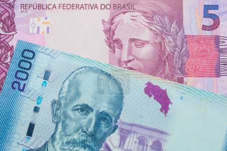 Photo for A macro image of a pink and purple five real bank note from Brazil paired up with a colorful two thousand colones bank note from Costa Rica.  Shot close up in macro. - Royalty Free Image