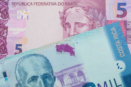 Foto de Una imagen macro de un billete de cinco reales rosa y púrpura de Brasil se emparejó con un colorido billete de banco de dos mil colones de Costa Rica. Disparo de cerca en macro. - Imagen libre de derechos