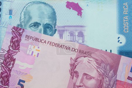 Foto de Una imagen macro de un billete de cinco reales rosa y púrpura de Brasil se emparejó con un colorido billete de banco de dos mil colones de Costa Rica. Disparo de cerca en macro. - Imagen libre de derechos