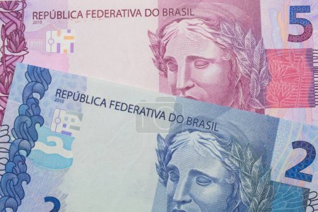 Téléchargez les photos : Une macro image d'un billet rose et violet de cinq vraies banques du Brésil jumelé avec un bleu deux vrai billet de banque du Brésil. Plan rapproché dans macro. - en image libre de droit