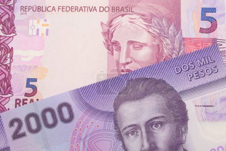 Téléchargez les photos : Une macro image d'un billet de banque rose et violet de cinq vraies du Brésil jumelé avec un violet, plastique deux mille billet de banque peso chilien. Plan rapproché dans macro. - en image libre de droit