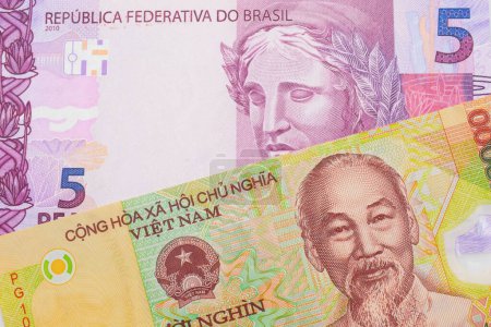 Foto de Una imagen macro de un billete de cinco reales rosa y púrpura de Brasil emparejado con un colorido billete de diez mil dong de Vietnam. Disparo de cerca en macro. - Imagen libre de derechos