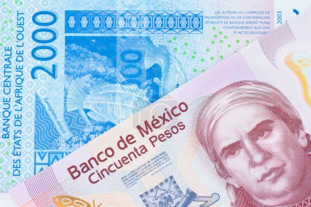 Téléchargez les photos : Une image macro d'un billet de banque rose en plastique de cinquante pesos en provenance du Mexique jumelé à un billet de banque bleu de deux mille francs ouest-africains. Plan rapproché dans macro. - en image libre de droit