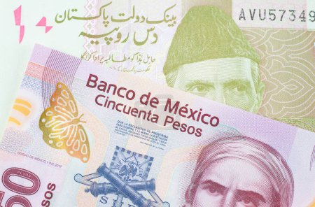 Photo for A macro image of a pink, plastic fifty peso bank note from Mexico paired up with a pink and grey ten rupee note from Pakistan.  Shot close up in macro. - Royalty Free Image