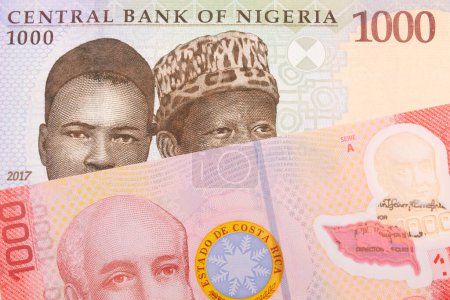 Photo for A macro image of a blue, purple and green one thousand  naira note from Nigeria paired up with a colorful red one thousand colones bank note from Costa Rica.  Shot close up in macro. - Royalty Free Image