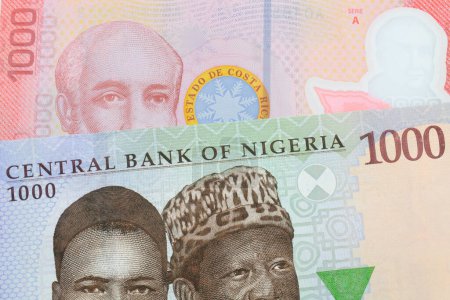 Photo for A macro image of a blue, purple and green one thousand  naira note from Nigeria paired up with a colorful red one thousand colones bank note from Costa Rica.  Shot close up in macro. - Royalty Free Image