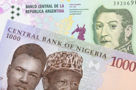 Photo for A macro image of a blue, purple and green one thousand  naira note from Nigeria paired up with a colorful five peso note from Argentina.  Shot close up in macro. - Royalty Free Image