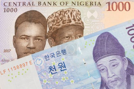 Photo for A macro image of a blue, purple and green one thousand  naira note from Nigeria paired up with a blue and white one thousand won bill from Korea.  Shot close up in macro. - Royalty Free Image