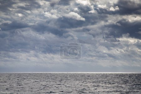 Téléchargez les photos : Paysage marin avec nuages sombres et lumière - en image libre de droit