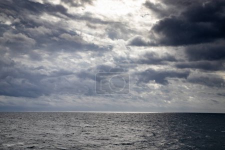 Téléchargez les photos : Paysage marin avec nuages sombres et lumière - en image libre de droit