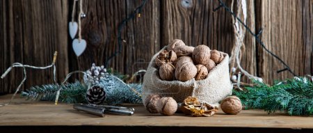 Photo for Festive christmas nuts tumbling from a burlap bag - Royalty Free Image